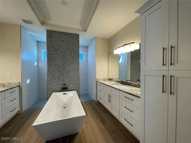 bathroom with a tile shower, hardwood / wood-style floors, and a healthy amount of sunlight