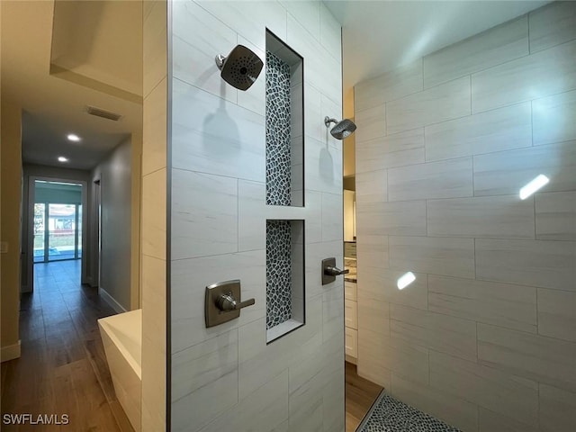 bathroom with hardwood / wood-style flooring and a tile shower