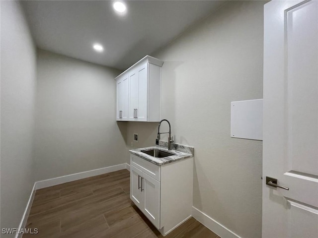 clothes washing area with hardwood / wood-style floors, sink, and washer hookup