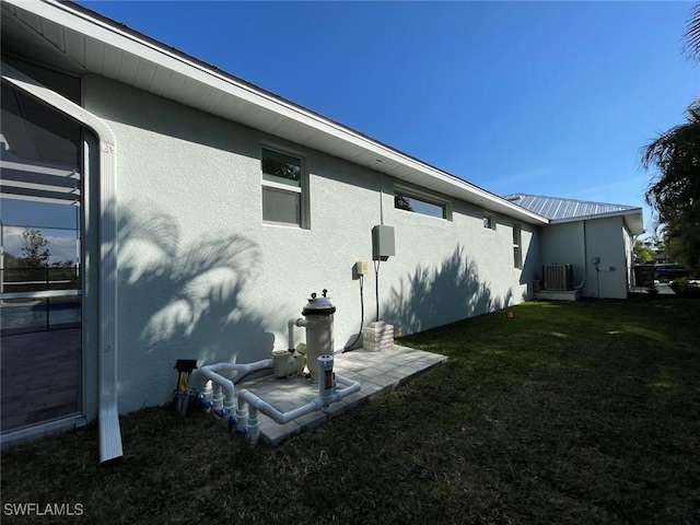 back of property featuring central AC and a lawn