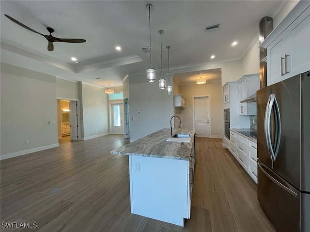 kitchen with sink, decorative light fixtures, stainless steel appliances, a kitchen island with sink, and white cabinets