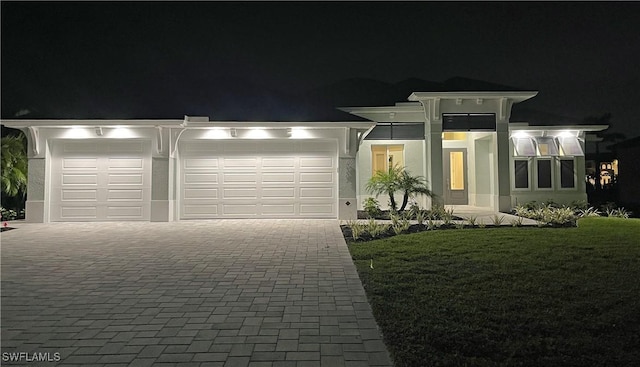 view of front of house with a garage and a lawn