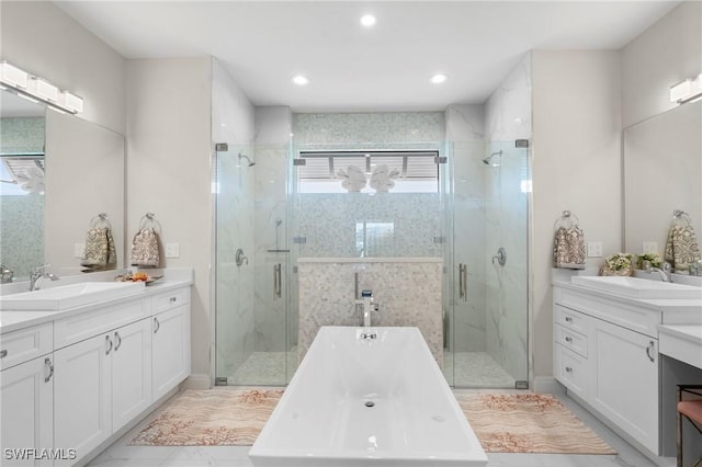 bathroom with vanity and shower with separate bathtub