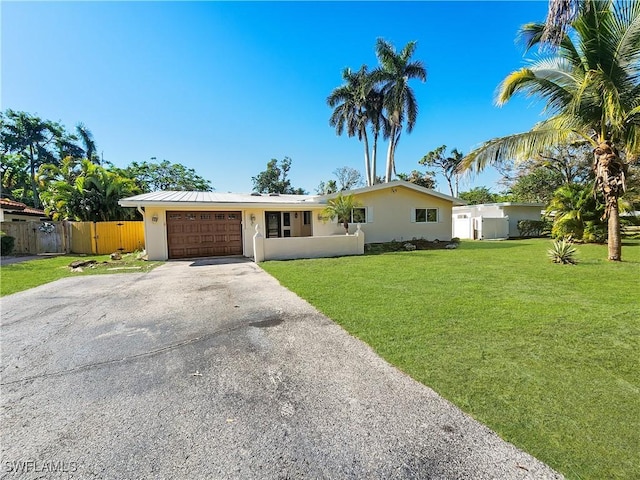 single story home featuring a garage and a front lawn