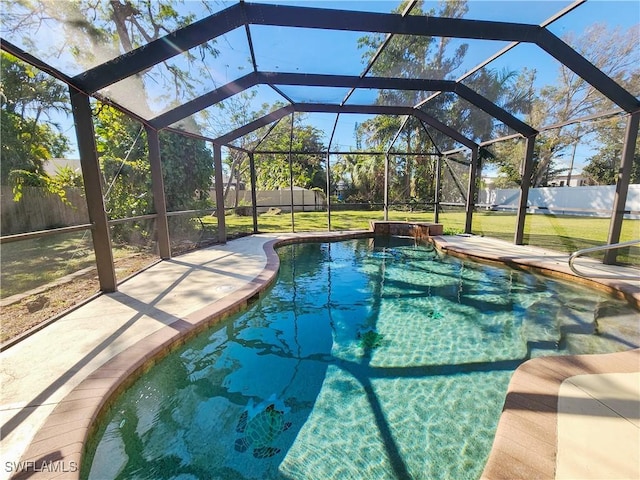 view of swimming pool with a lanai and a lawn