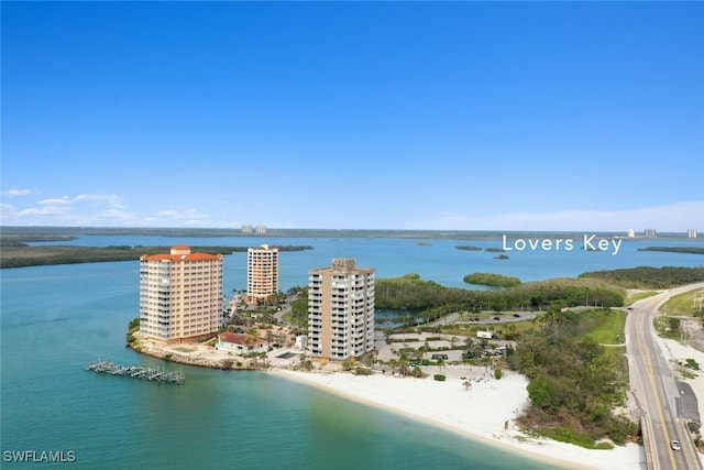 birds eye view of property featuring a water view and a beach view