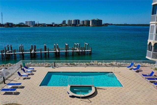 view of pool featuring a patio and a water view