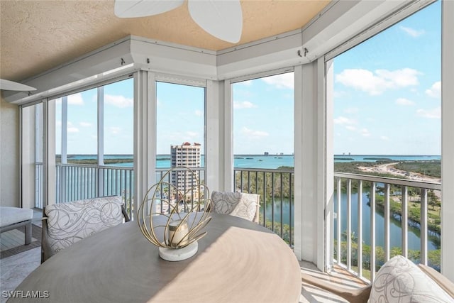 sunroom featuring a water view