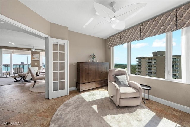 sitting room with a wealth of natural light, french doors, and ceiling fan