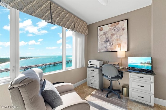 office space with light tile patterned flooring and a water view