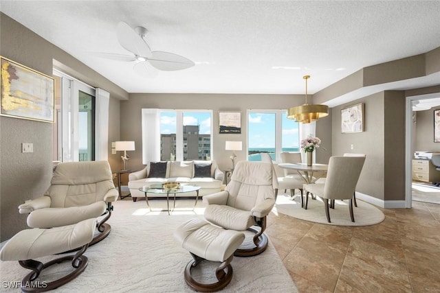 living room with a textured ceiling and ceiling fan