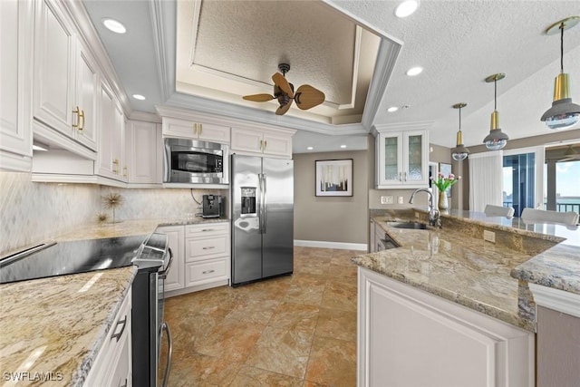 kitchen with built in appliances, sink, decorative light fixtures, and white cabinetry