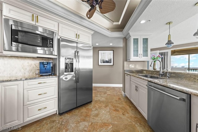 kitchen with stainless steel appliances, hanging light fixtures, sink, and white cabinets