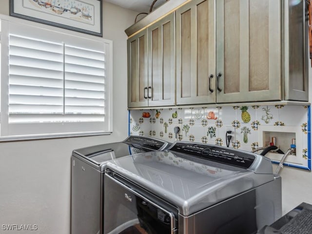 clothes washing area with cabinets and separate washer and dryer