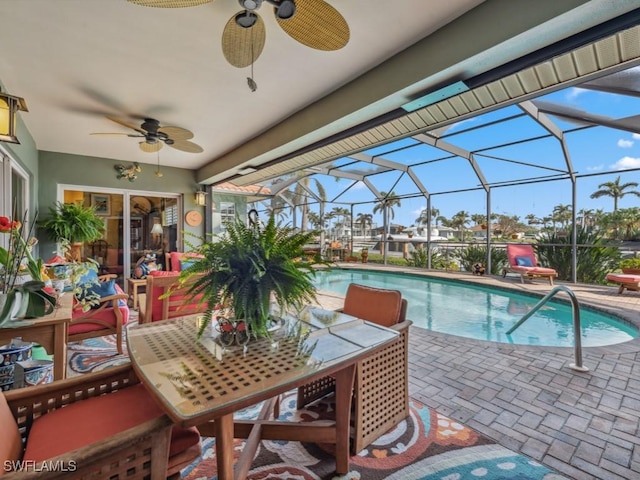 view of pool with ceiling fan, glass enclosure, and a patio