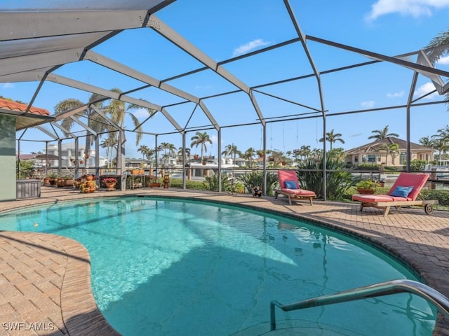 view of pool with a patio area and glass enclosure