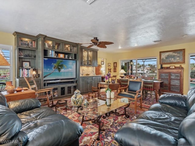 living room with ceiling fan and sink