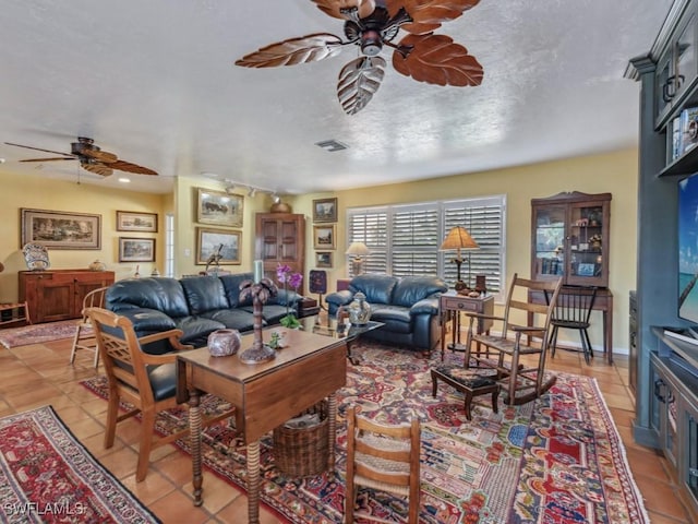 tiled living room featuring a textured ceiling and ceiling fan