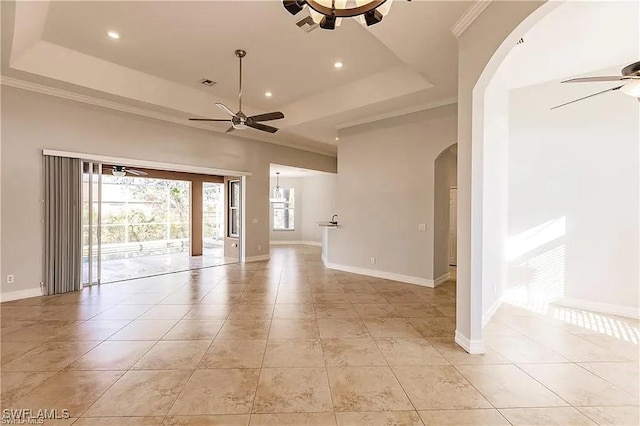 tiled spare room with ceiling fan, ornamental molding, and a tray ceiling