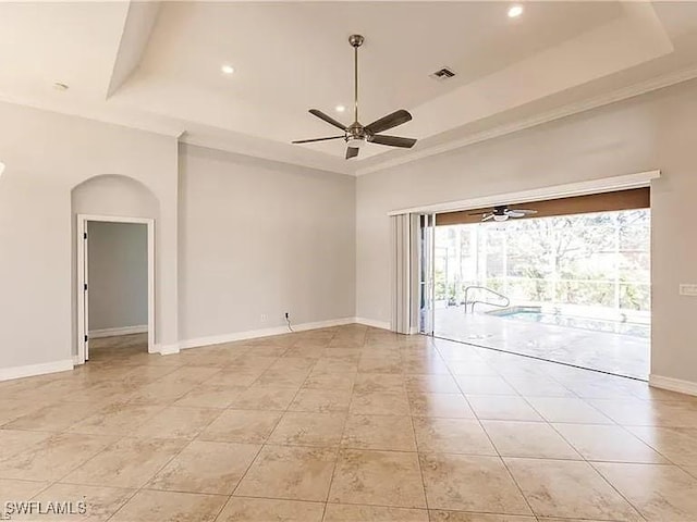 tiled spare room with crown molding, ceiling fan, a tray ceiling, and a high ceiling