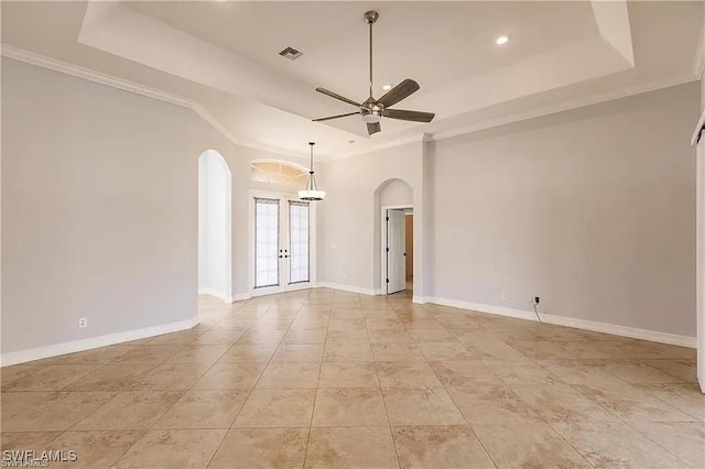 tiled spare room with ornamental molding, a raised ceiling, and ceiling fan