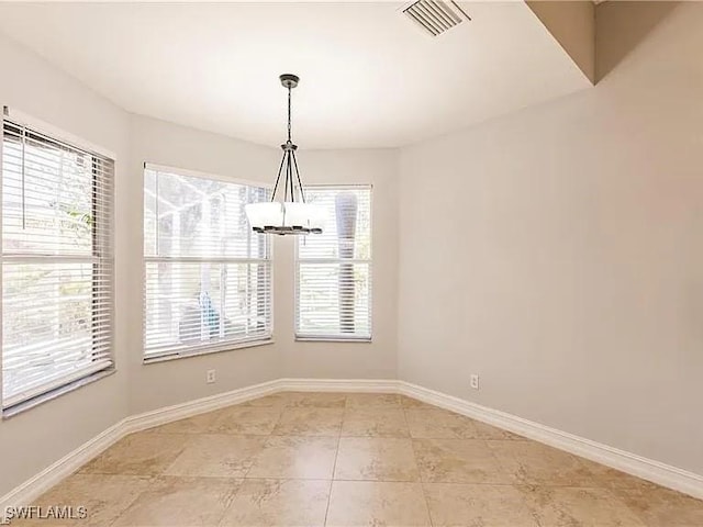 unfurnished dining area featuring light tile patterned flooring, plenty of natural light, and a notable chandelier