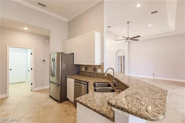 kitchen with stainless steel appliances, sink, light stone counters, and kitchen peninsula