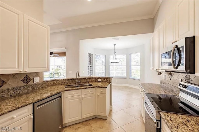 kitchen featuring pendant lighting, sink, appliances with stainless steel finishes, white cabinetry, and dark stone counters