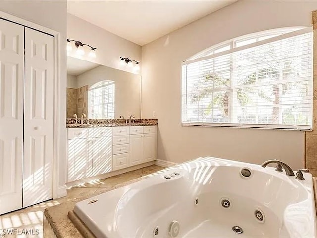 bathroom with tile patterned floors, vanity, and a bath