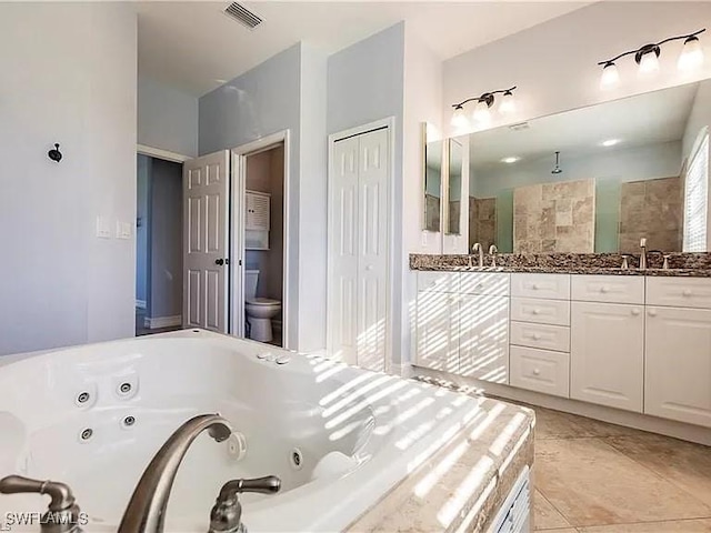 bathroom with vanity, tile patterned floors, toilet, and walk in shower