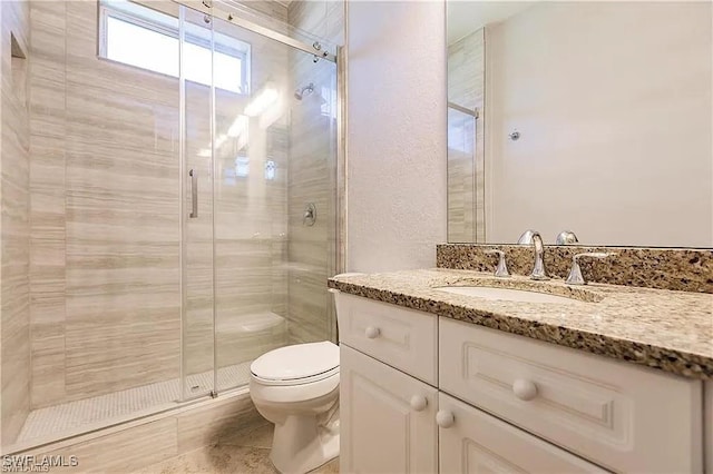 bathroom with vanity, walk in shower, and toilet