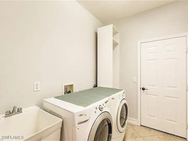 washroom with washing machine and dryer, sink, and light tile patterned flooring