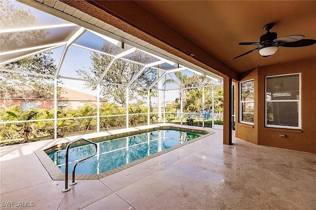 view of swimming pool with ceiling fan, a patio, and glass enclosure