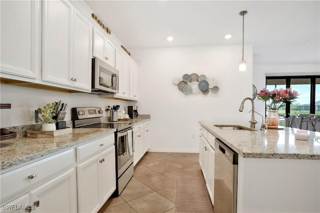 kitchen with appliances with stainless steel finishes, sink, pendant lighting, and white cabinets