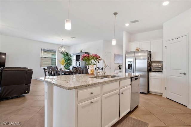 kitchen with decorative light fixtures, white cabinetry, sink, a kitchen island with sink, and stainless steel appliances