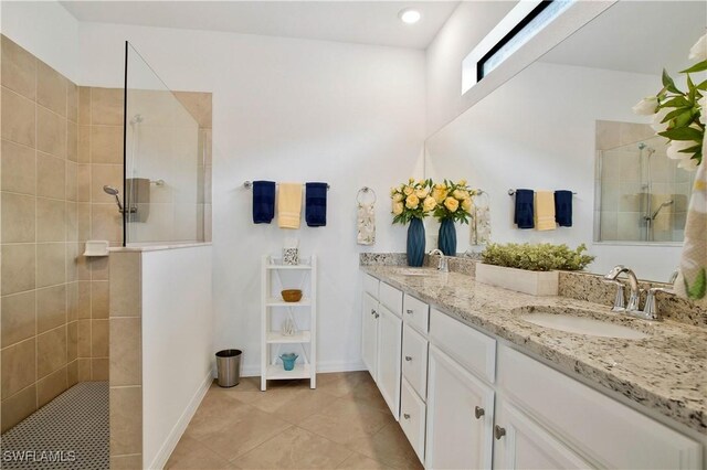 bathroom featuring tile patterned floors, vanity, and a tile shower