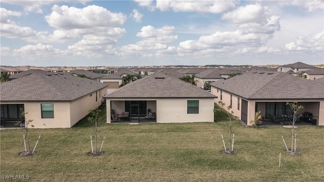 back of property with a lawn and a patio