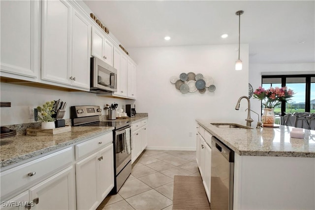 kitchen featuring stainless steel appliances, white cabinetry, sink, and decorative light fixtures