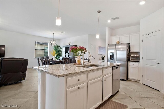 kitchen featuring sink, a kitchen island with sink, stainless steel appliances, white cabinets, and decorative light fixtures