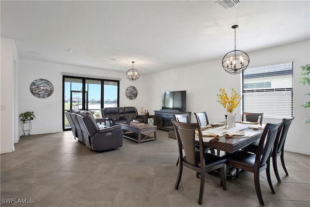 dining room with a notable chandelier and tile patterned floors