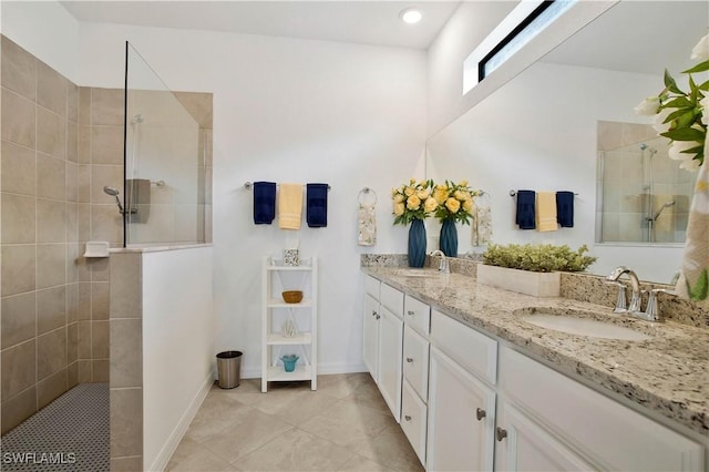 bathroom featuring vanity, tile patterned flooring, and a tile shower