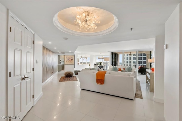 living room with light tile patterned flooring, a chandelier, and a raised ceiling