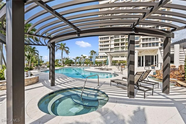 view of swimming pool with a hot tub and a patio area