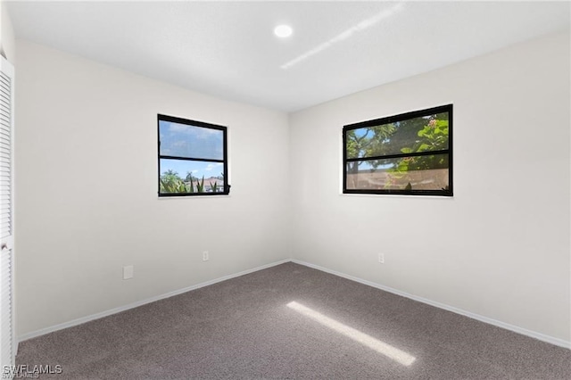 carpeted spare room featuring plenty of natural light