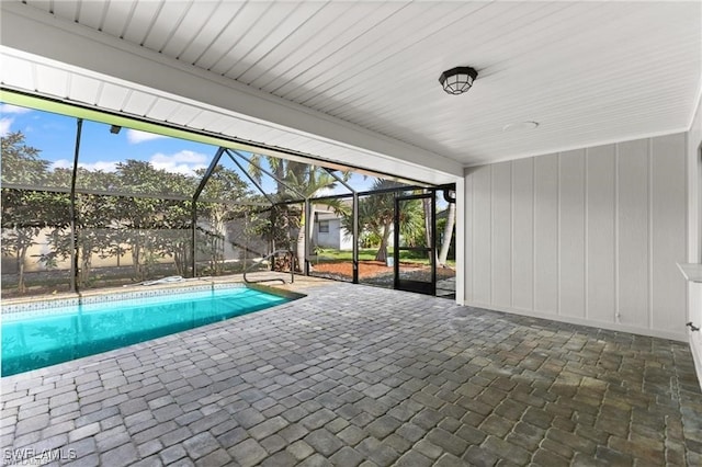 view of swimming pool with glass enclosure and a patio area