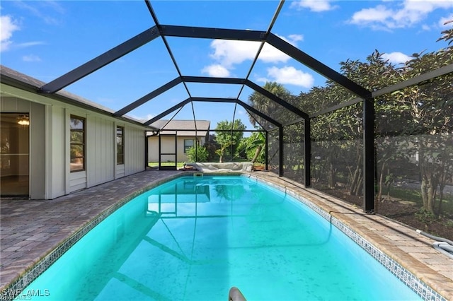 view of pool with a patio and glass enclosure