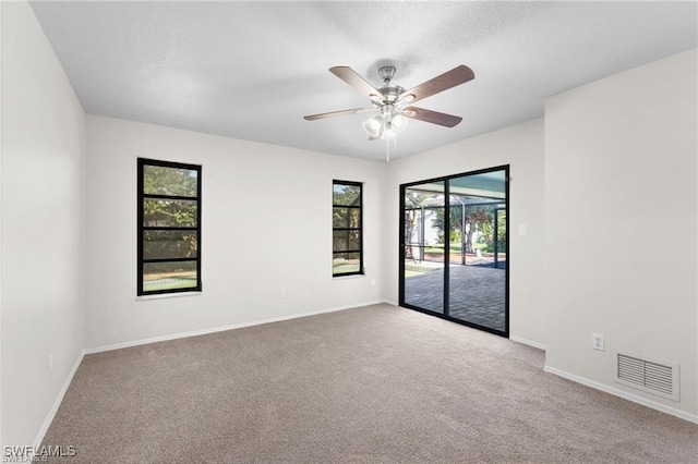 carpeted spare room with ceiling fan