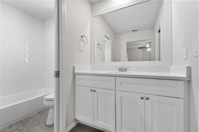 full bathroom featuring vanity, ceiling fan, bathtub / shower combination, and toilet