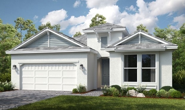 view of front of property featuring a garage, decorative driveway, a front lawn, and stucco siding