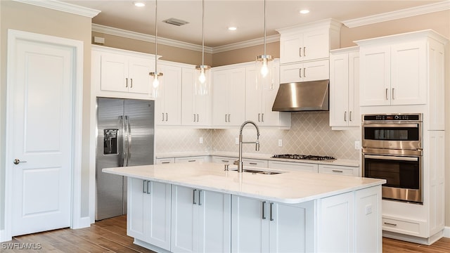 kitchen with decorative light fixtures, a center island with sink, stainless steel appliances, a sink, and under cabinet range hood